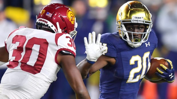 Notre Dame Fighting Irish running back C'Bo Flemister (20) carries as USC Trojans safety Chris Thompson Jr. (30) defends in 2021.