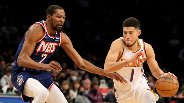 Phoenix Suns guard Devin Booker (1) drives with the ball around Brooklyn Nets forward Kevin Durant (7).